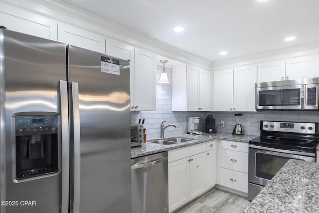 kitchen featuring a sink, backsplash, white cabinetry, and stainless steel appliances