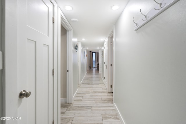 hall with recessed lighting and baseboards