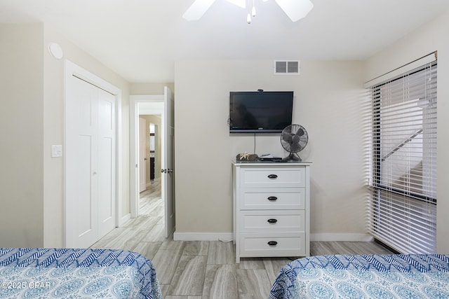 bedroom featuring visible vents, baseboards, ceiling fan, and light wood-style floors