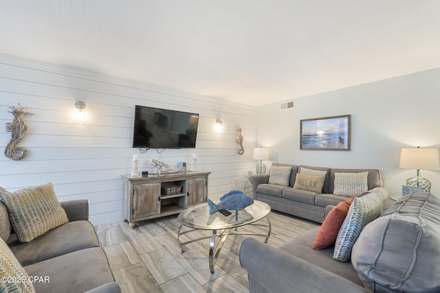 living room with wood walls and visible vents