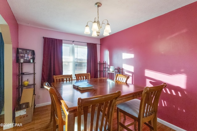 dining space featuring hardwood / wood-style floors and a notable chandelier