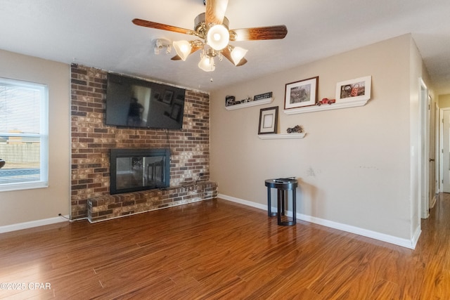 unfurnished living room with hardwood / wood-style floors, a fireplace, and ceiling fan