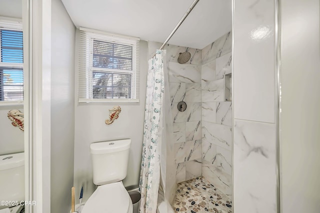 bathroom with curtained shower and toilet