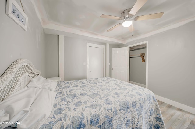 bedroom featuring ceiling fan, light wood-type flooring, and a closet