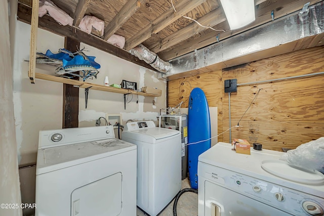 clothes washing area featuring water heater and washer and dryer