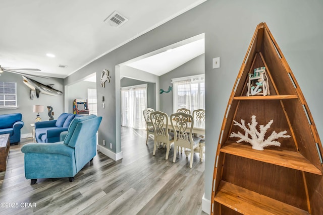 living room featuring ceiling fan, ornamental molding, vaulted ceiling, and hardwood / wood-style floors