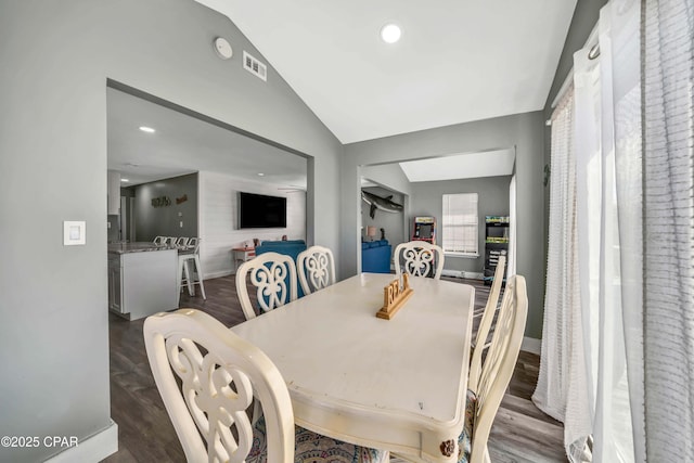 dining room featuring dark wood-type flooring and vaulted ceiling