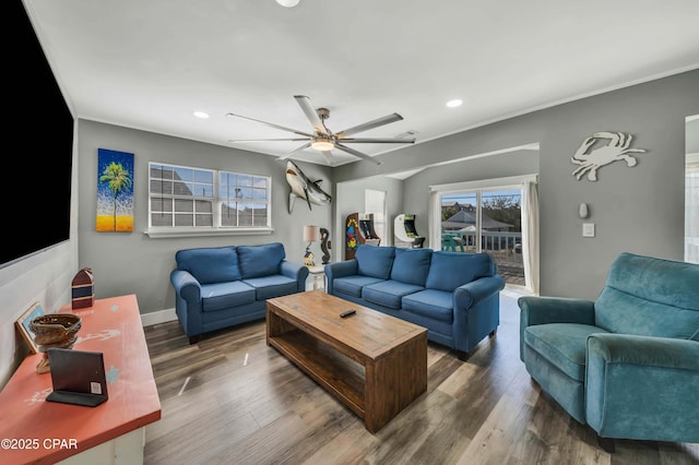 living room featuring hardwood / wood-style flooring, ornamental molding, and ceiling fan