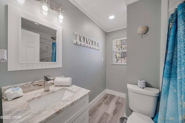 bathroom featuring vanity, wood-type flooring, ornamental molding, toilet, and walk in shower