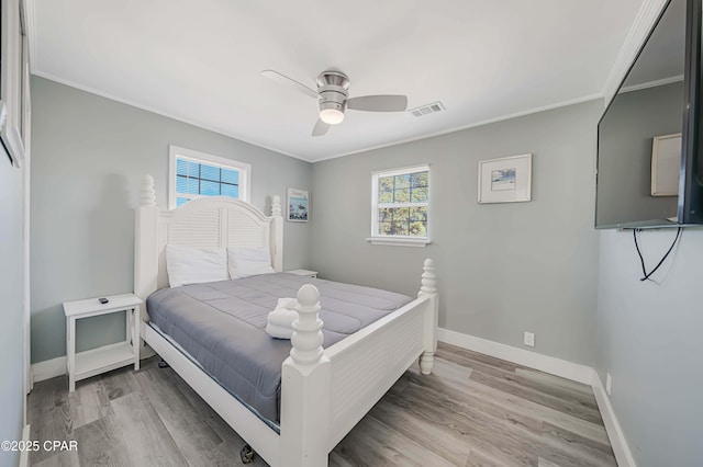 bedroom with hardwood / wood-style flooring, ceiling fan, and ornamental molding