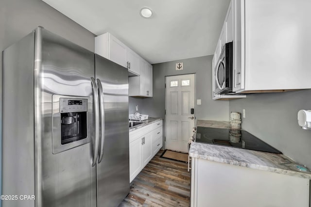 kitchen with appliances with stainless steel finishes, dark wood-type flooring, sink, and white cabinets