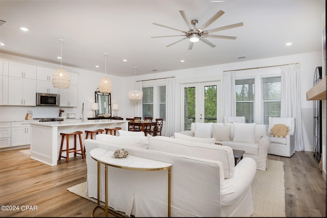 living room with visible vents, recessed lighting, french doors, and light wood-type flooring