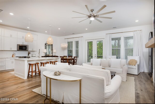 living room with visible vents, recessed lighting, french doors, and light wood-type flooring