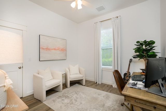 office area with a ceiling fan, wood finished floors, visible vents, and baseboards