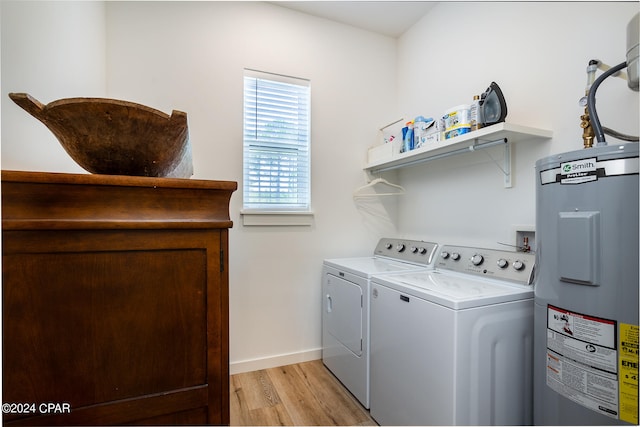 laundry room featuring baseboards, light wood finished floors, laundry area, separate washer and dryer, and water heater