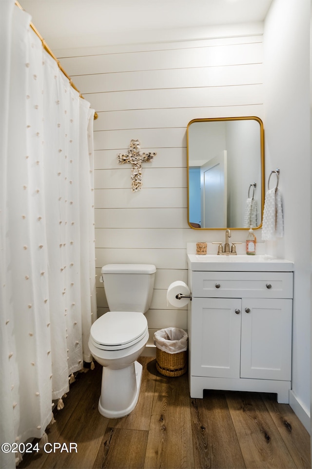 full bathroom with vanity, curtained shower, toilet, and wood finished floors