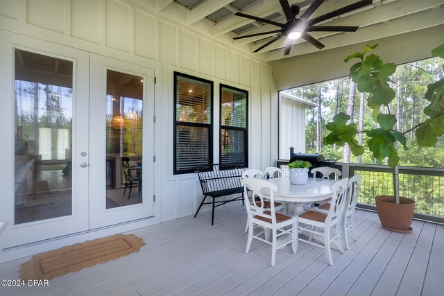 sunroom / solarium featuring a wealth of natural light, beam ceiling, and a ceiling fan