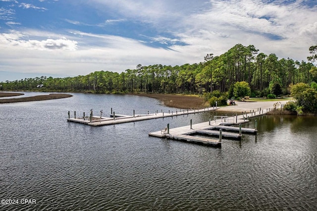 view of dock featuring a forest view and a water view