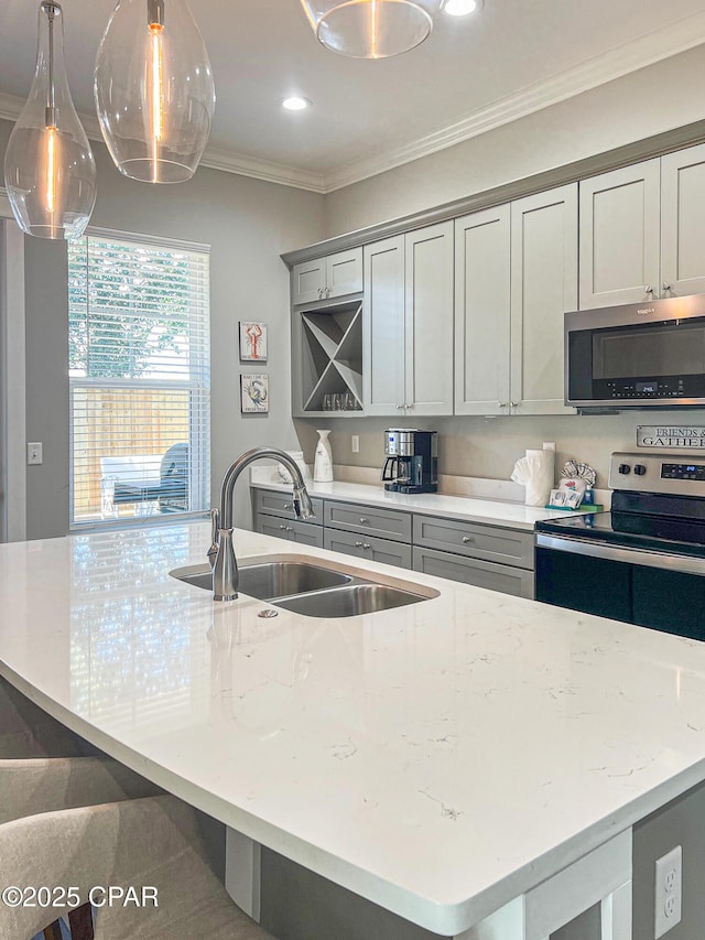 kitchen featuring light stone counters, a sink, appliances with stainless steel finishes, a large island with sink, and crown molding