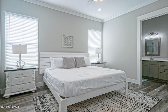 bedroom featuring baseboards, ornamental molding, dark wood finished floors, and a sink