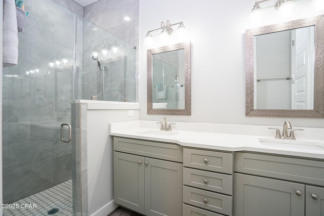 bathroom with a stall shower, a sink, and double vanity