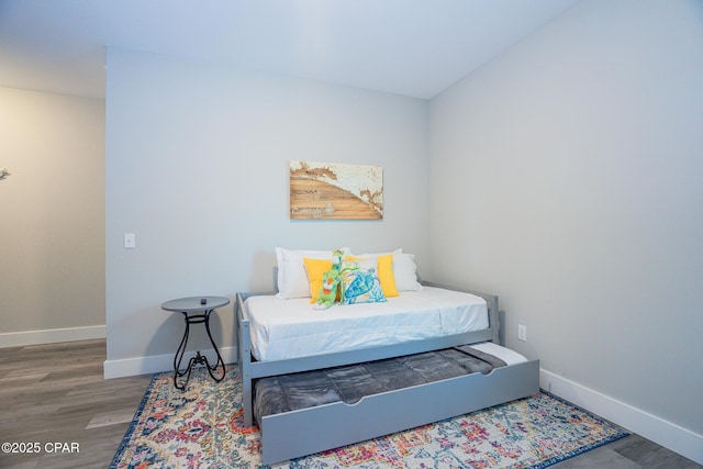 bedroom with baseboards and wood finished floors