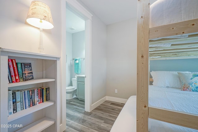 corridor with wood finished floors, visible vents, and baseboards