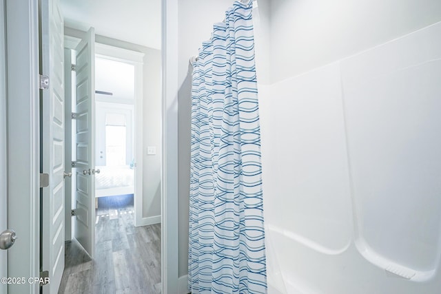 bathroom with wood finished floors and baseboards