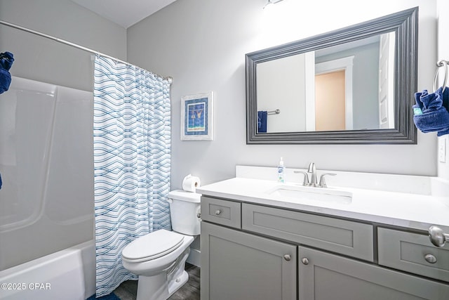 full bath featuring toilet, shower / bath combo with shower curtain, and vanity