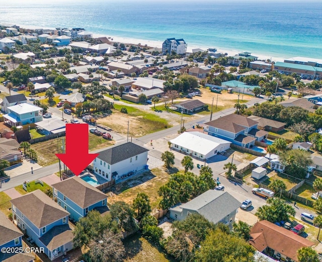 drone / aerial view with a view of the beach, a residential view, and a water view