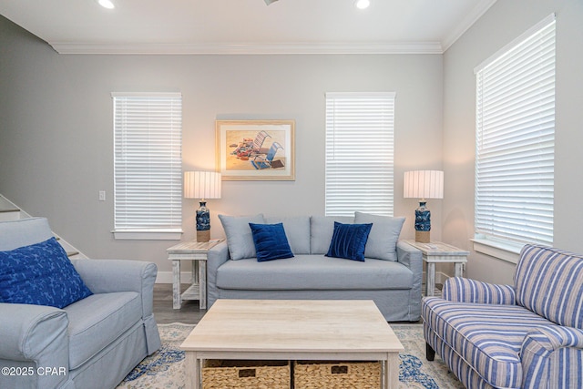 living room with a wealth of natural light, crown molding, and wood finished floors