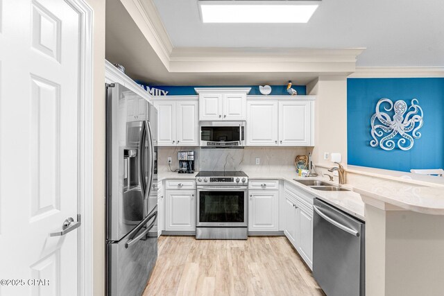 kitchen with white cabinetry, ornamental molding, and appliances with stainless steel finishes