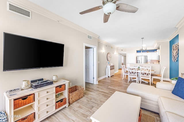 living room featuring crown molding, ceiling fan, and light hardwood / wood-style flooring