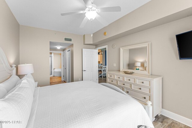 bedroom featuring ceiling fan, ensuite bathroom, and light hardwood / wood-style floors