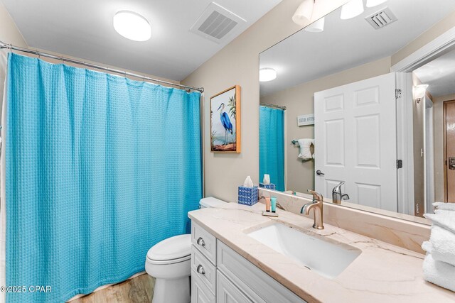 bathroom with wood-type flooring, toilet, and vanity