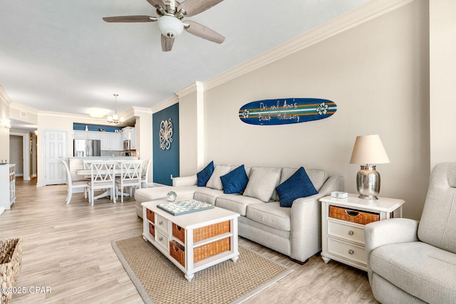 living room with crown molding, light hardwood / wood-style flooring, and ceiling fan with notable chandelier