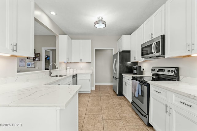 kitchen with white cabinetry, appliances with stainless steel finishes, kitchen peninsula, and sink