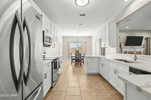 kitchen with sink, white cabinetry, hanging light fixtures, appliances with stainless steel finishes, and kitchen peninsula