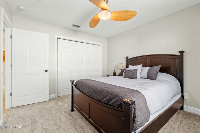 carpeted bedroom with ceiling fan and a closet