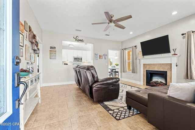 tiled living room with a fireplace and ceiling fan