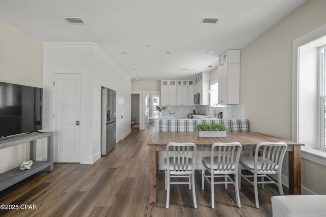 dining space featuring sink, a wealth of natural light, and dark wood-type flooring