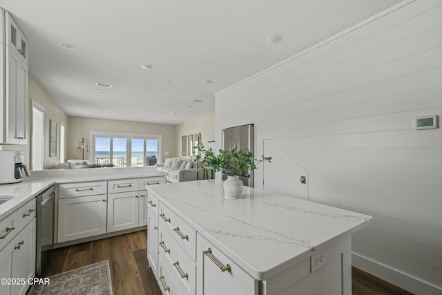 kitchen with white cabinetry, light stone countertops, dark wood-type flooring, and kitchen peninsula