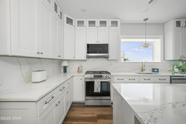 kitchen featuring white cabinetry, appliances with stainless steel finishes, and decorative light fixtures