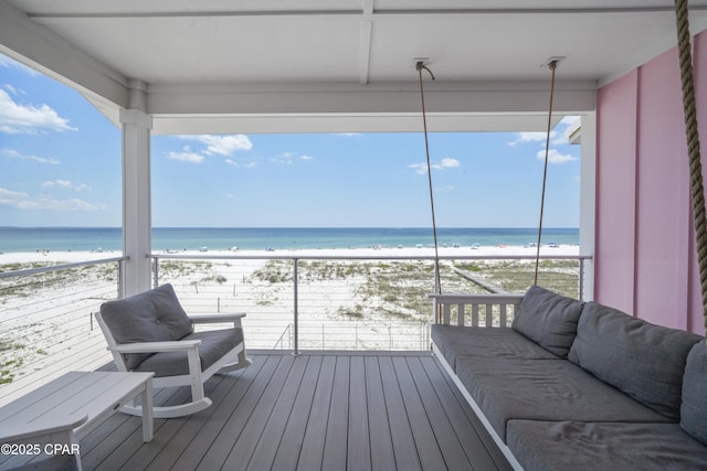 wooden deck with a water view and a beach view