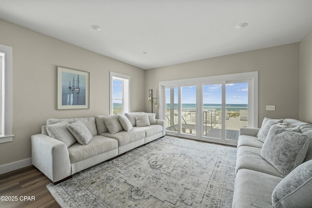 living room with a water view and dark hardwood / wood-style floors