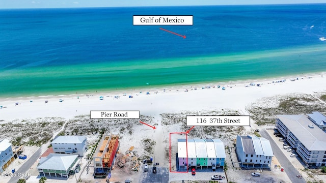 drone / aerial view featuring a water view and a beach view