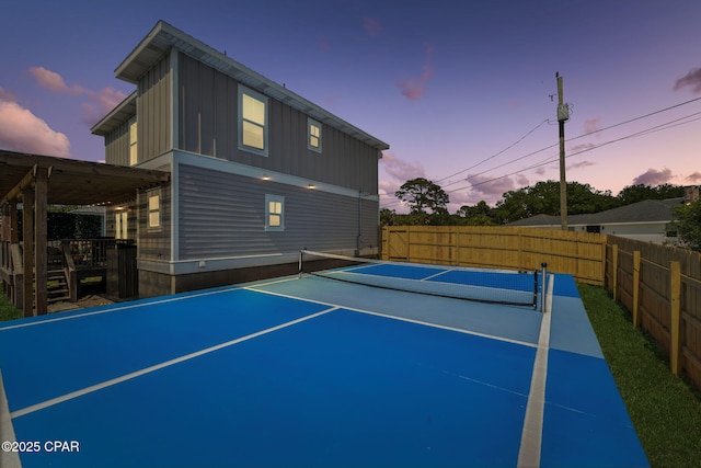 view of sport court with a tennis court and fence