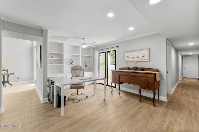 office space featuring crown molding, ceiling fan, light wood-type flooring, and built in shelves