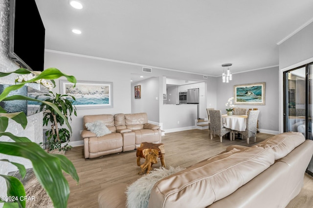 living room with ornamental molding and light hardwood / wood-style flooring