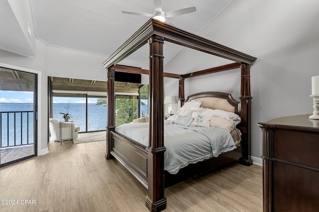 bedroom with a water view, access to exterior, vaulted ceiling, and light hardwood / wood-style flooring